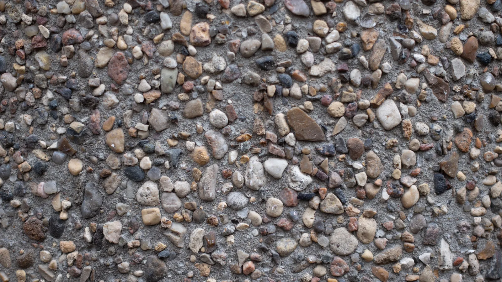 Close-up of exposed aggregate concrete texture showing natural stone finish
